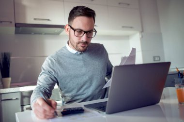 Mutfakta, oturma ve onun laptop çalışma neşeli yakışıklı genç adam.