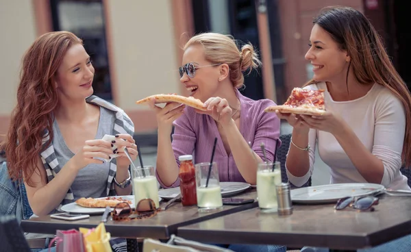 Friends eating pizza in cafe,enjoying together in lunch.