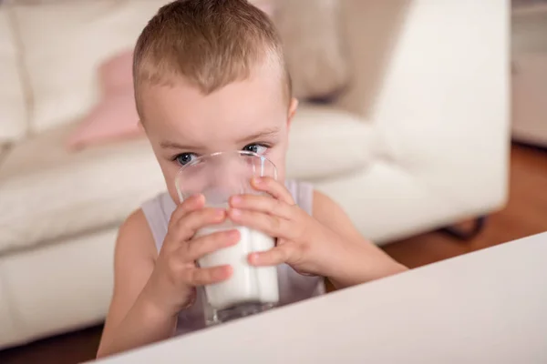 美丽的小男孩喝牛奶从玻璃 — 图库照片