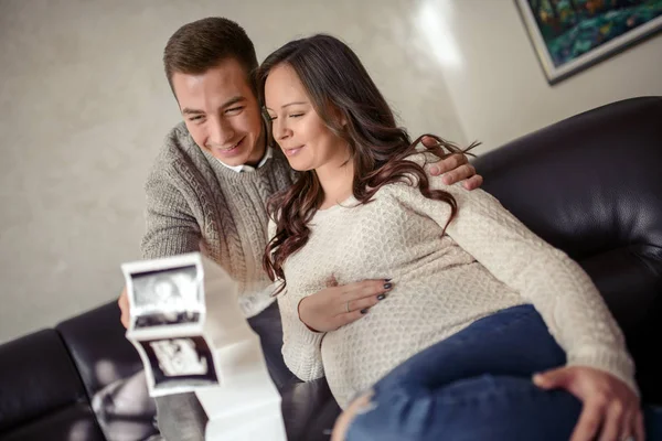 Happy Pregnant Woman and Her Husband Looking Ultrasound Scan Photo Album on  Bed Stock Image - Image of expecting, background: 141046041