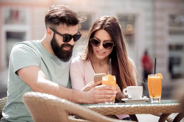 Junges Paar Trinkt Kaffee Café Lächelt Schaut Aufs Smartphone Und — Stockfoto