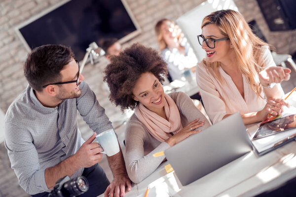 Трое уверенных бизнесменов обсуждают что-то, ища документ вместе
.