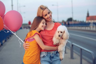 güzel anne ve kızı şehirde gün ışığı, su birikintisi ile eğlenmek