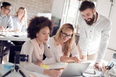 İş ortaklarının toplantıda belge ve fikirleri tartıştığı resim.