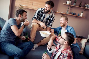 Genç çocuklar içki şişeleri ile dinlenme, patlamış mısır yemek, futbol hakkında konuşuyor ve gülümseyen.