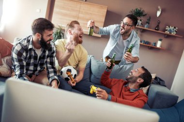 Evde eğlenmek, futbol TV izlerken mutlu erkek arkadaşlar