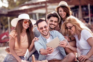 Selfie akıllı telefon ile sahilde alarak neşeli arkadaş grubu.