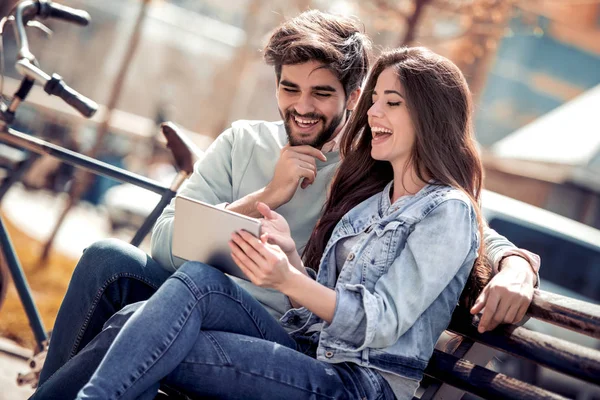 Pareja Joven Sentada Banco Del Parque Divirtiéndose Con Tableta — Foto de Stock