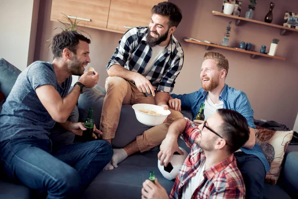 Genç çocuklar içki şişeleri ile dinlenme, patlamış mısır yemek, futbol hakkında konuşuyor ve gülümseyen.