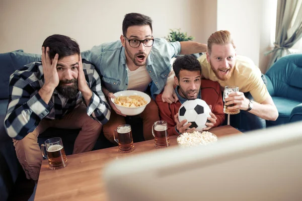 テレビでサッカーの試合を見ている友人のグループ — ストック写真