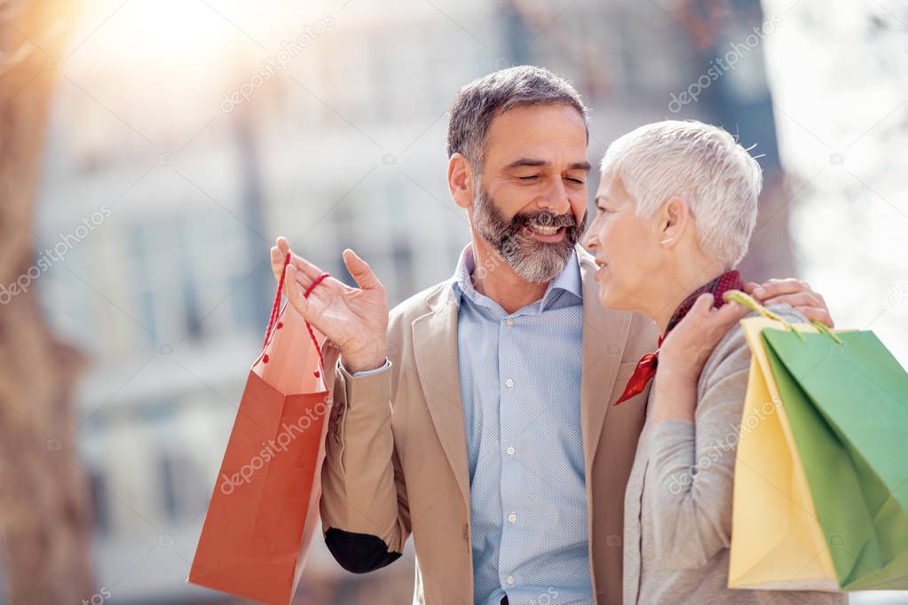 Cheerful mature couple enjoying shopping together.