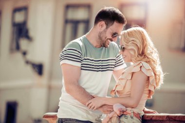 eğleniyor ve açık havada ışığında sarılma genç çift gülümseyen