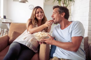 Mutlu genç çift rahatlatıcı ve evde Tv izlerken.