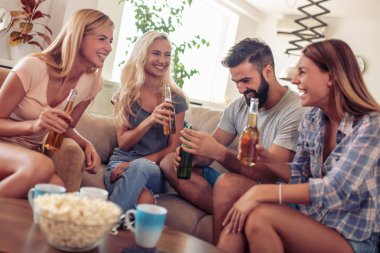 Neşeli grup arkadaşıyla evde maç izlerken.