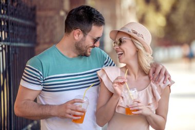 portakal suyu içme ve gün ışığından yararlanma şehirde gülüyor güzel genç çift