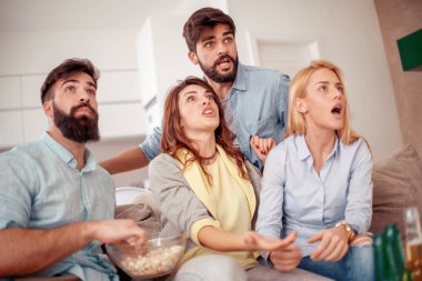 Neşeli grup arkadaşıyla evde maç izlerken