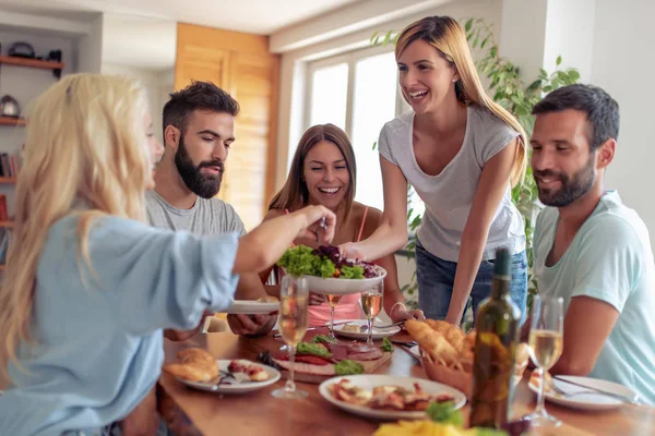 Group of friends eating lunch together and having great time at home