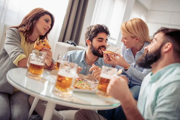 Friends having party at home,eating pizza.