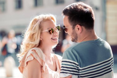 Genç çift gündüz vakti dışarıda eğleniyor gülümseyen