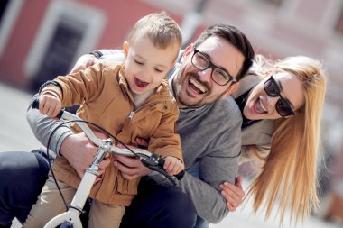 Genç baba oğulu mather öğretim şehirde bisiklet sokak sürmek.