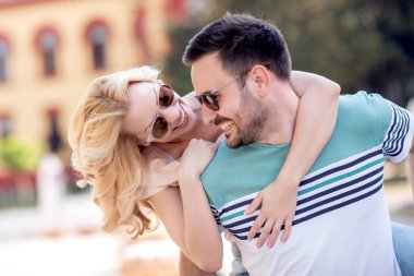 eğleniyor ve açık havada ışığında sarılma genç çift gülümseyen