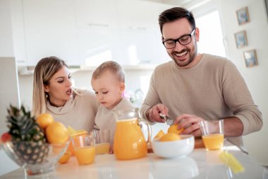 mutlu aile eğleniyor ve portakal suyu modern mutfakta yapma