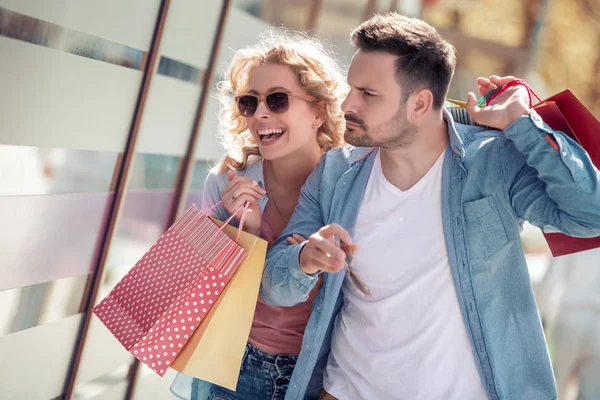 美丽的情侣购物袋购物后在城市微笑和笑在日光下 — 图库照片