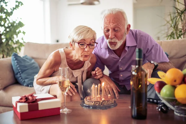 Szczęśliwa Para Starszy Zdmuchujące Świeczki Torcie Świętuje Urodziny Domu — Zdjęcie stockowe