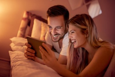 Genç çift Tablet yatağa gece kullanma.
