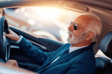 Kendine güvenen üst düzey işadamı sürüş araba