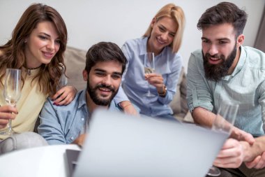 Birlikte kanepede oturan ve dizüstü film izlerken arkadaşlar.