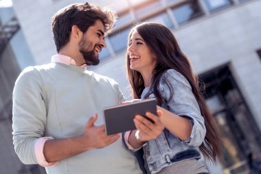 Genç çift şehir sokak tablet bilgisayar kullanarak