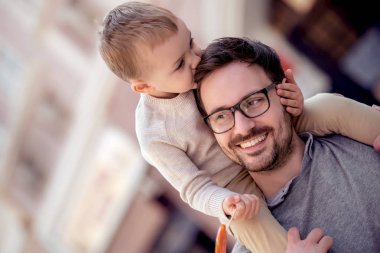 Mutlu baba veren oğlu Sırtıma binmek onun omuzlarında portresi. Açık havada oynama baba ile sevimli çocuk
