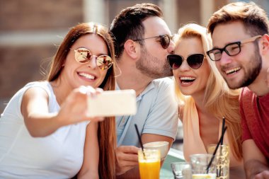 Neşeli grup arkadaşıyla kafede eğleniyor.