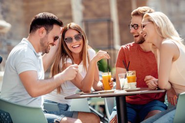 Neşeli grup arkadaşıyla kafede eğleniyor.