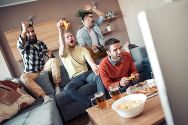 Evde eğlenmek, futbol TV izlerken mutlu erkek arkadaşlar