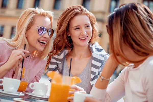 Group of female friends enjoying coffee together in cafe