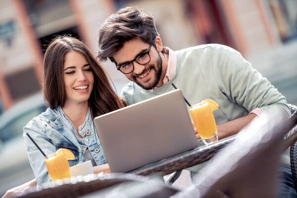young couple on dating in cafe using laptop