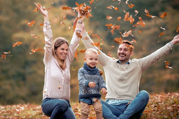 Счастливая Семья Весело Бросает Осенние Листья Парке Дневном Свете — стоковое фото