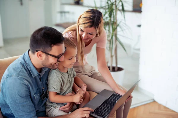 Happy family using laptop at home.