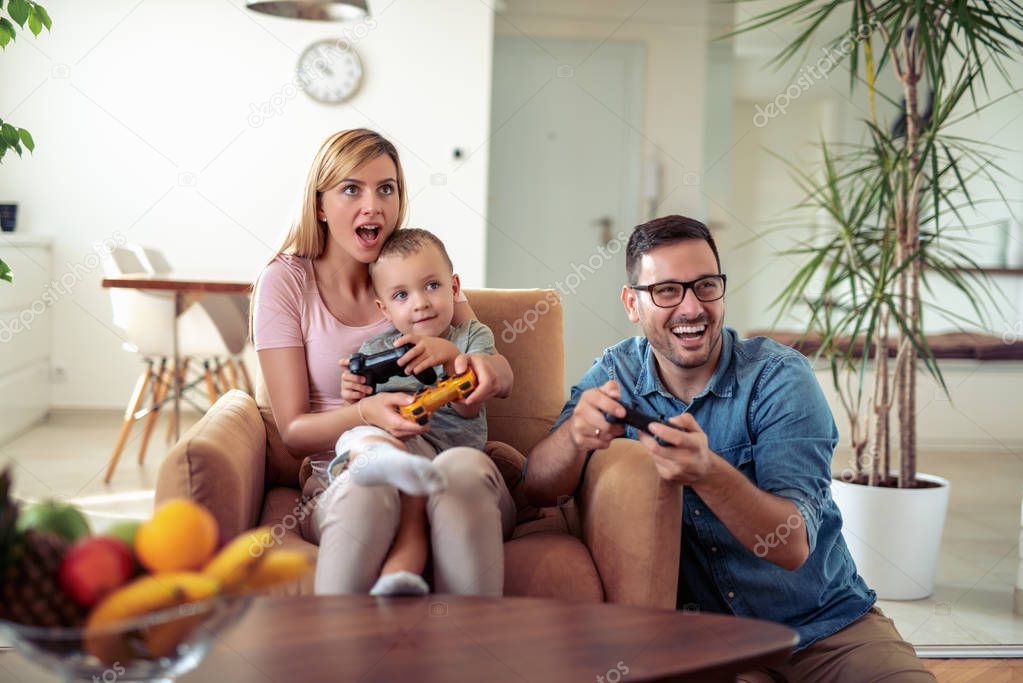 Happy family playing video games at home.