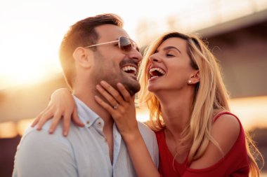 Mutlu genç çift dışarıda eğleniyor ve gülümsüyor..