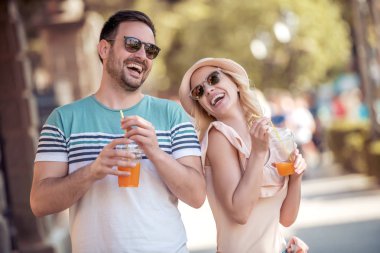 Genç çift ferahlatıcı parkta portakal suyu ile.