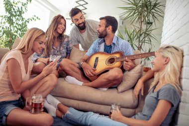 Evde parti, gitar çalan arkadaş.