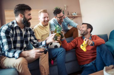 Dostluk, teknoloji, Oyunlar ve ev kavramı gülümseyen erkek arkadaşlar bira içmek ve video oyunları evde oynamak.