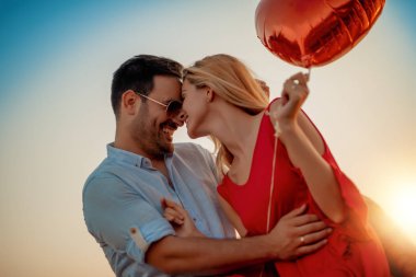 Mutlu genç çift dışarıda eğleniyor ve gülümsüyor..