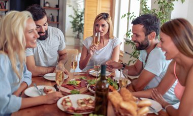Mutlu genç insanlar yeme, söz ve evde yemek yaparken gülümseyen.