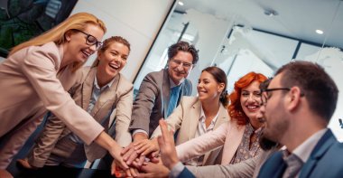 Bir grup iş adamı el ele tutuşuyor..