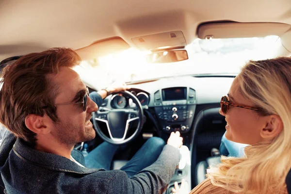 Enjoying road trip together.Happy young couple having fun while riding in their car.