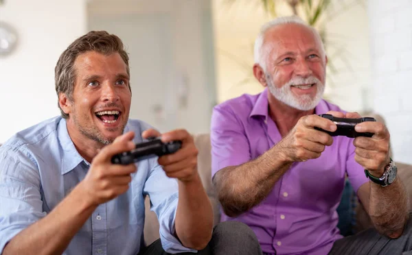 Image of two excited men playing video games at home.